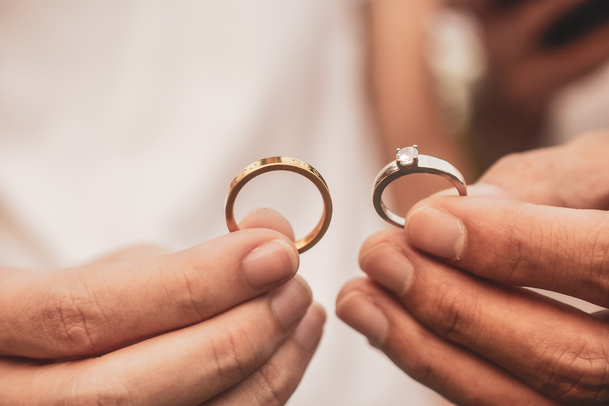 Hand Holding Engagement Ring and Wedding Ring